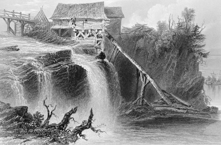 Black and white engraving of a small rudimentary wooden installation located near waterfalls. The mill is located between a wooden bridge and a wooded cliff.